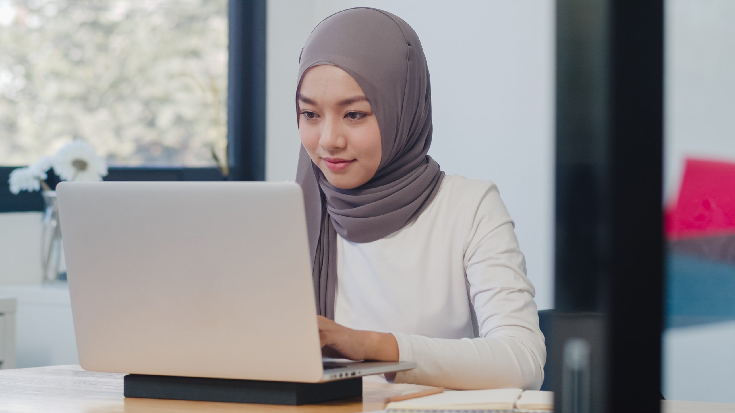 Beautiful Asia muslim lady casual wear working using laptop in m